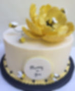 Bumple bees on yellow peony on cake.